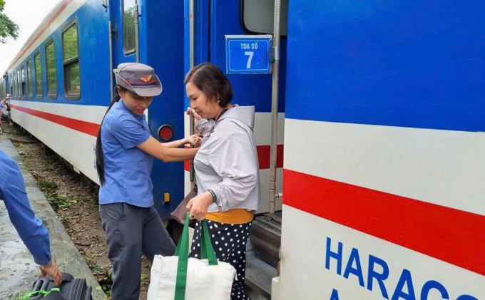 Hành khách được chuyển khi đường sắt ngập nước không thể lưu thông. Ảnh: Xuân Hoa