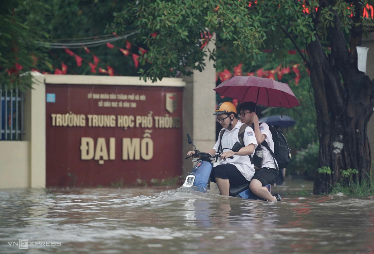 Học sinh tan trường trong cơn mưa lớn. Ảnh: Hoàng Giang