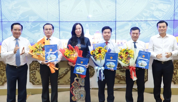 Ông Võ Hoàng Ngân (thứ ba, phải qua) và các phó giám đốc Sở Quy hoạch - Kiến trúc TP HCM nhận quyết định và hoa từ lãnh đạo UBND TP HCM. Ảnh: Lê Tuyết
