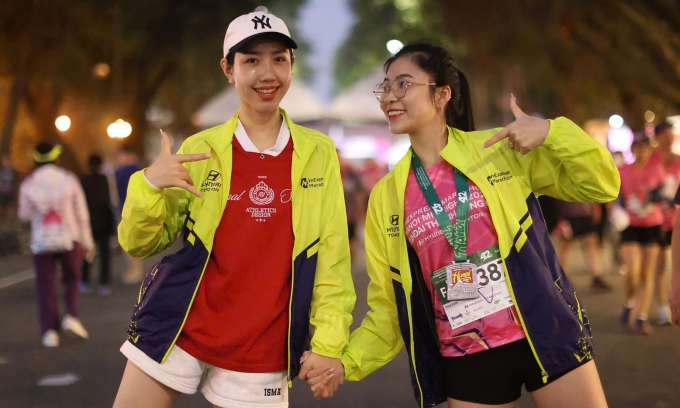 Hai runner mặc áo khoác finisher sau khi hoàn thành giải chạy đêm VnExpress Marathon Hanoi Midnight 2024. Ảnh: VnExpress Marathon