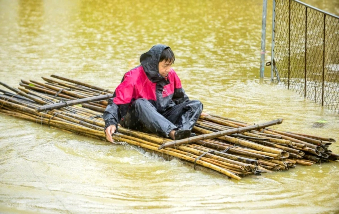 Người đàn ông ở xã Xuân Lập dùng chiếc bè tự chế bơi vào căn nhà của gia đình đã ngập sâu ngày 30/9. Ảnh: Lam Sơn