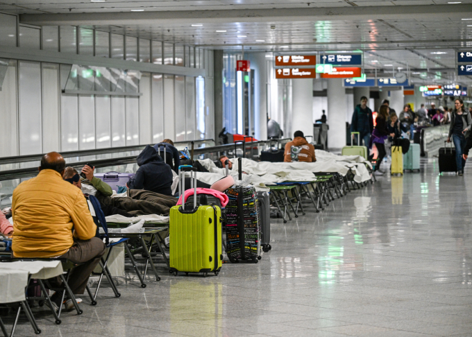 Hành khách nằm chờ ở sân bay Munich khi hàng loạt chuyến bay bị hủy hôm 2/10. Ảnh: Reuters