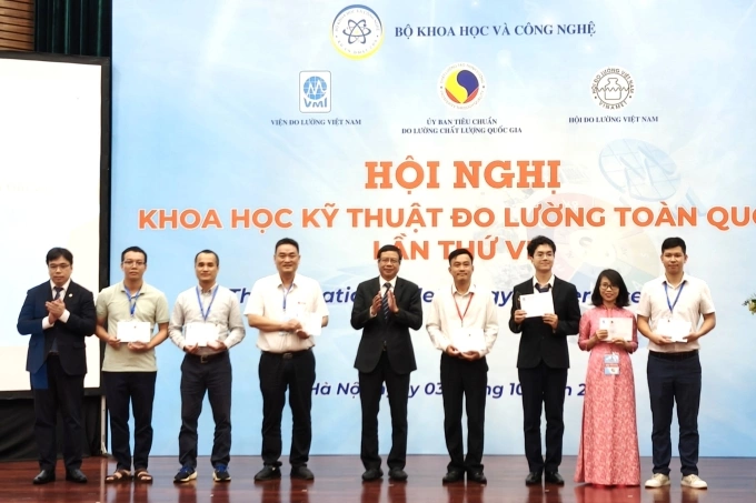 Thứ trưởng Lê Quang Định và Chủ tịch Ủy ban Tiêu chuẩn Đo lường Chất lượng Việt Nam Nguyễn Nam Hải trao kỷ niệm chương và quà cho một số nhà khoa học có báo cáo được vinh danh. Ảnh: Trọng Đạt