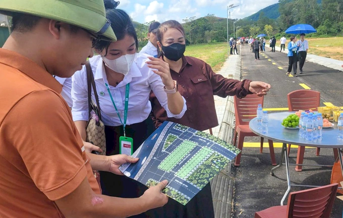Nhân viên Công ty Đông Quân LAND tư vấn cho khách hàng mua đất tại dự án đất nền ven sông ở xã Toàn Lưu, ngày 20/9. Ảnh: Hùng Lê