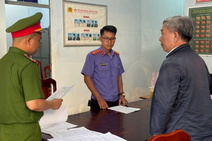 Bị can Nguyễn Văn Thành (bên phải) nghe cảnh sát đọc lệnh bắt tạm giam. Ảnh: VKSND Lâm Đồng