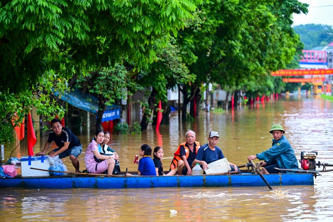 Dùng thuyền cứu hộ tiếp tế cho người dân vùng ngập lụt tỉnh Lào Cai sau bão Bualoi. Ảnh: Giang Huy