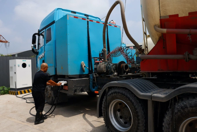 Một tài xế đang sạc chiếc xe tải điện hạng nặng Sany tại trạm sạc ở tỉnh Hà Bắc (Trung Quốc), tháng 7/2025. Ảnh: Tingshu Wang