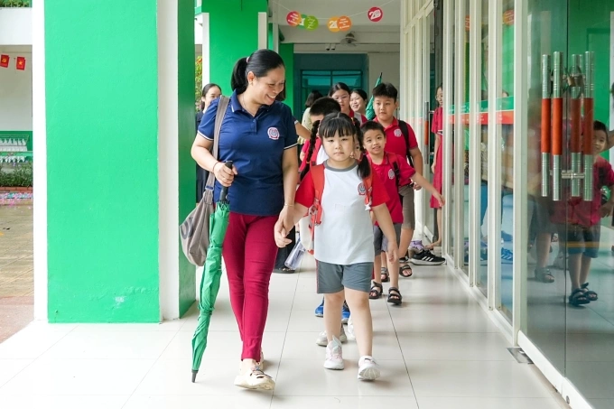 Học sinh trường Tiểu học Lê Quý Đôn, phường Mỹ Đình 1, rời trường sáng 1/10 sau một đêm ngủ lại vì mưa lớn gây ngập. Ảnh: Fanpage nhà trường