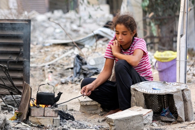 Thiếu nữ Palestine đun nước tại khu lều trại dành cho người sơ tán ở Khan Younis, miền nam Dải Gaza, ngày 6/10. Ảnh: AFP
