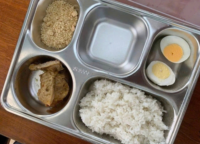 Suất ăn 25.000 đồng gồm cơm trắng, một quả trứng, vài lát chả cá và muối lạc. Ảnh: Thanh Thảo.
