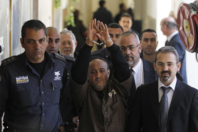 Thủ lĩnh phong trào Fatah Marwan Barghouti (giữa) được áp giải đến tòa án ở Jerusalem hồi tháng 1/2012. Ảnh: Reuters