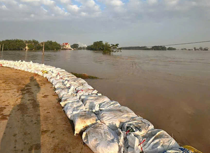 Người dân dùng bao cát ngăn nước vào làng ở thôn Đa Hội, xã Hợp Thịnh, Bắc Ninh. Ảnh: Nguyễn Thoa