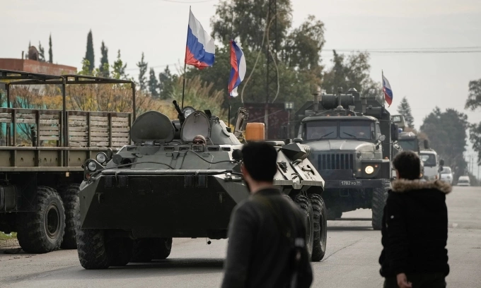 Các tay súng Syria quan sát đoàn xe Nga tiến vào căn cứ Hmeimim hôm 16/12/2024. Ảnh: AP