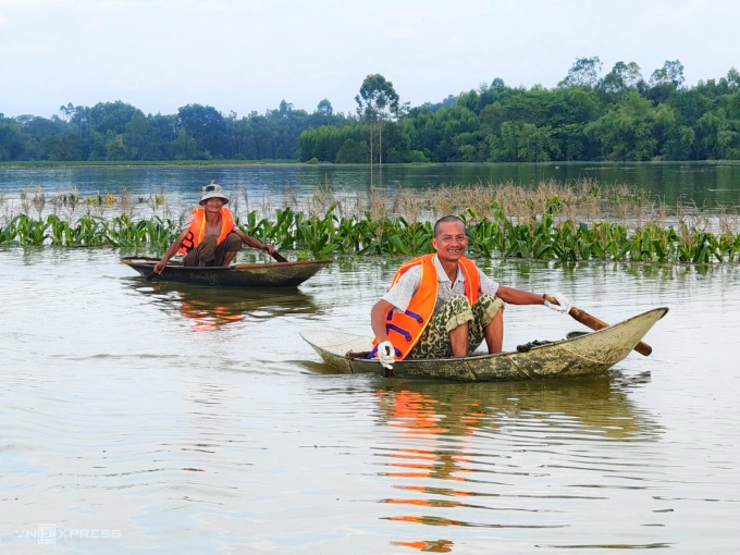 Người dân xã Mỹ Thái ven bờ sông Thương bơi xuồng đi nhận đồ tiếp tế từ các đoàn thiện nguyện, chiều 11/10. Ảnh: Trung Đào