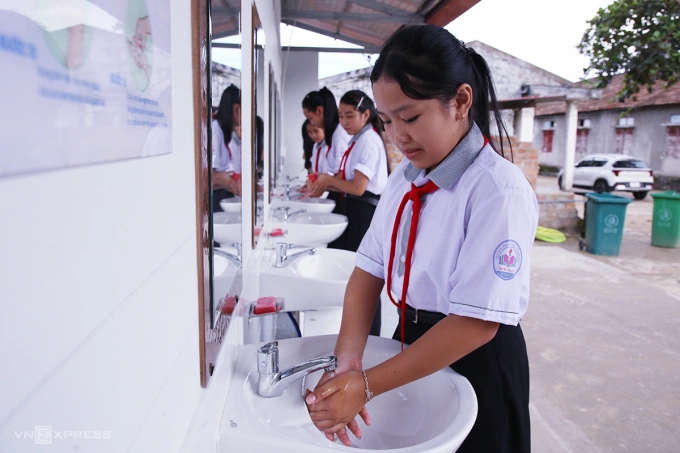 Học sinh Trường THCS số 2 Hưng Trạch vệ sinh tay sau khi đi vệ sinh. Ảnh: Đắc Thành