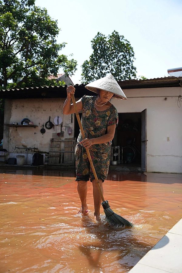 Người dân xã Trung Giã dọn rác cho nước nhanh lưu thoát sau đợt mưa ngập ngày 12/10. Ảnh: Văn Ngọc