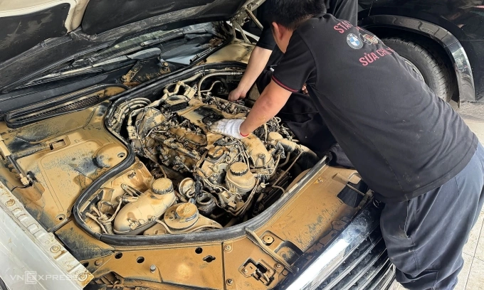 Nhân viên garage đang kiểm tra khoang máy của xe ngập nước. Ảnh: Minh Quân