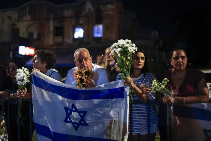 Người dân cầm hoa đón đoàn xe chở thi thể 4 con tin được Hamas bàn giao cho Israel hôm 13/10. Ảnh: AFP
