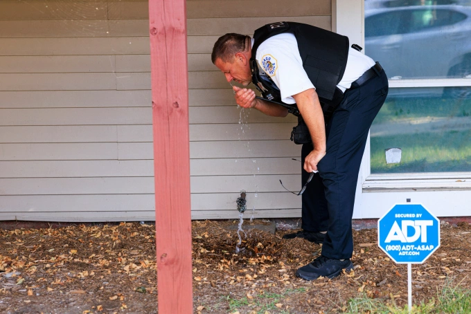 Cảnh sát Chicago rửa mắt sau khi bị ảnh hưởng bởi hơi cay ở khu East Side, ngày 14/10. Ảnh: AP