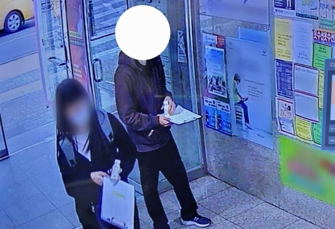 Hai người cầm đồ uống có pha ma túy để phát cho học sinh ở Gangnam trong bức ảnh do camera giám sát ghi lại hồi tháng 4/2023. Ảnh: Korea Times
