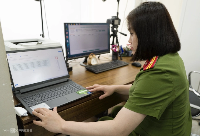 Cán bộ công an kiểm tra lại phần ghi âm của công dân khi thu thập dữ liệu giọng nói, trong ngày đầu tiên của Luật Căn cước 2023 có hiệu lực, 1/7/2024. Ảnh: Ngọc Thành