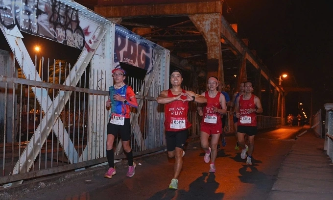 Nhóm runner sải bước trên Cầu Long Biên tại VnExpress Marathon Hanoi Midnight 2024. Ảnh: VnExpress Marathon