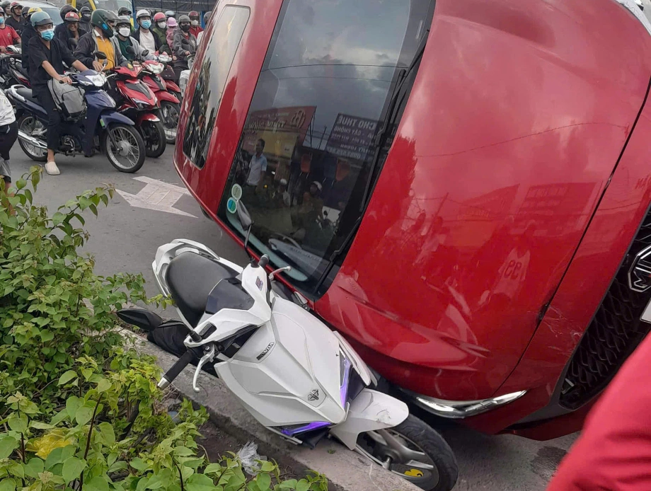 Một xe máy bị ôtô lật đè lên. Ảnh: Thái Hà Một xe máy bị ôtô lật đè lên. Ảnh: Thái Hà