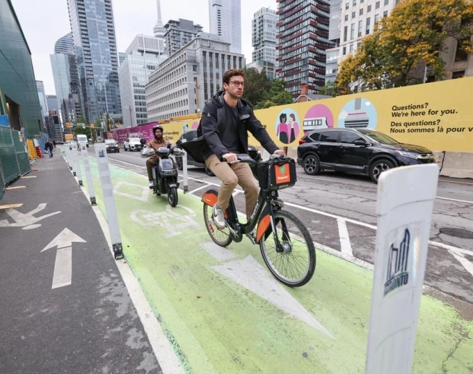 Xe đạp điện và xe máy điện di chuyển trong làn xe đạp ở Toronto. Ảnh: Toronto Star