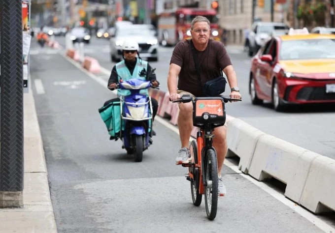 Xe đạp điện và xe máy điện di chuyển trên đường phố Toronto. Ảnh: Toronto Star