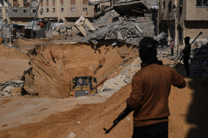Thành viên Hamas tìm kiếm thi thể con tin Israel thiệt mạng ở Khan Younis, Gaza ngày 19/10. Ảnh: AP