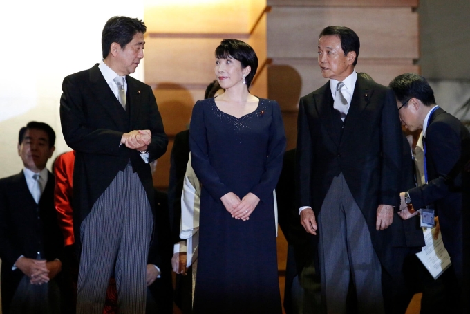 Bà Takaichi (giữa) tham dự một sự kiện với thủ tướng Shinzo Abe hồi năm 2014. Ảnh: Reuters