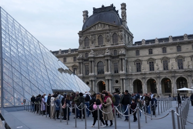 Du khách xếp hàng vào bảo tàng Louvre, Paris, sáng 22/10. Ảnh: AP