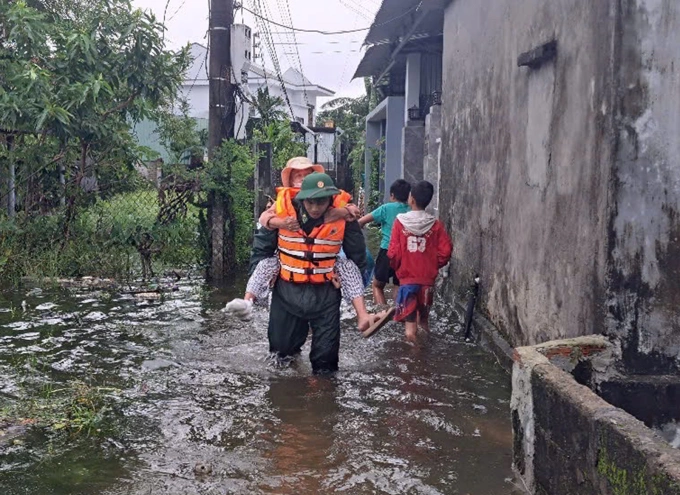 Chiến sĩ Biên phòng TP Huế hỗ trợ người dân đến nơi an toàn, ngày 22/10. Ảnh: BTL Biên phòng
