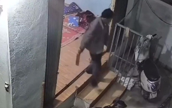 Người đàn ông cầm dao ra ngoài sau khi chém người ở xã Đăk Hà, tối 23/10. Ảnh camera an ninh