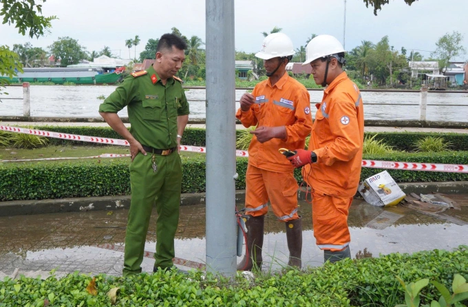 Cảnh sát và điện lực kiểm tra hiện trường trụ đèn bị rò rỉ điện, chiều 24/10. Ảnh: An Bình