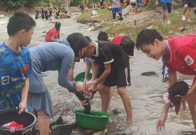 Nhà trường phải cử giáo viên đi cùng trông coi, hỗ trợ học sinh trên suối để đảm bảo an toàn. Ảnh: Lam Sơn