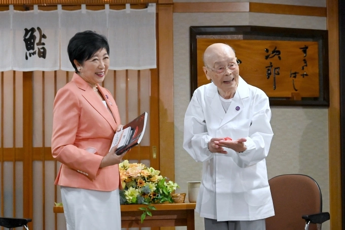 Thống đốc Tokyo Yuriko Koike chúc mừng sinh nhật 100 tuổi của ông Jiro Ono trước nhà hàng của ông ở Tokyo ngày 18/9. Ảnh: AP