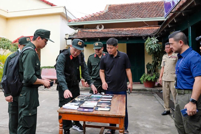 Công an kiểm tra tang vật lừa đảo qua mạng. Ảnh: Linh Đan