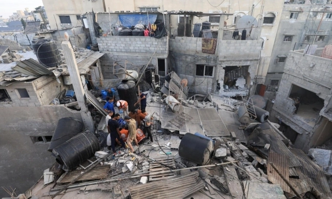 Nhân viên cứu hộ tìm kiếm nạn nhân từ đống đổ nát của một ngôi nhà bị hư hại do cuộc không kích trong đêm của Israel ở Gaza City ngày 29/10. Ảnh: Reuters