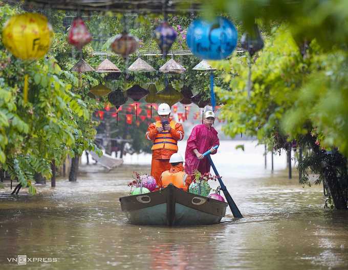 Nhân viên điện lực ngồi thuyền kiểm tra tình trạng điện lưới tại phố cổ Hội An bị ngập lũ. Ảnh: Nguyễn Đông