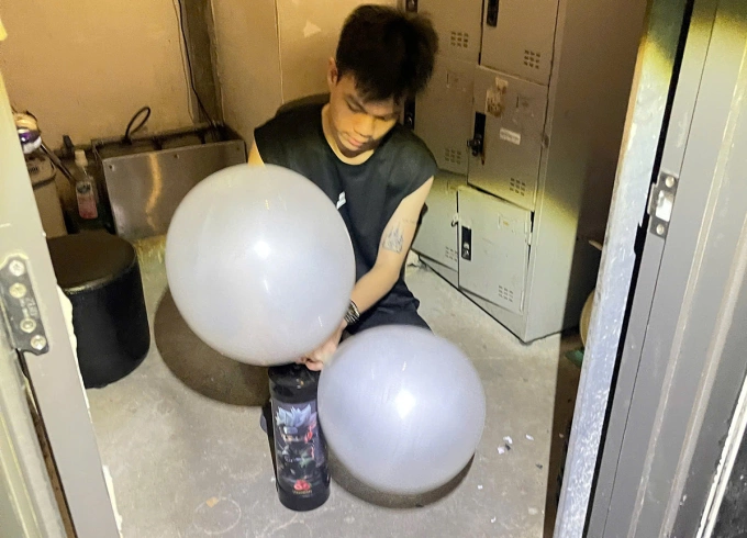 Nhân viên thực hiện việc bơm bóng cười cho khách. Ảnh: Công an TP HCM