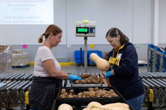Tình nguyện viên Mỹ chuẩn bị bí đỏ, khoai tây tại Ngân hàng Thực phẩm Central Texas ở Austin, ngày 30/10. Ảnh: Reuters