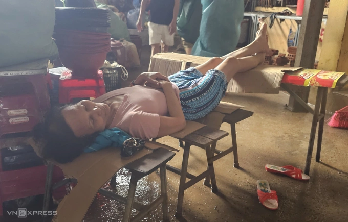 Bà Điểm tranh thủ chợp mắt khi nước lũ rút. Ảnh: Đắc Thành
