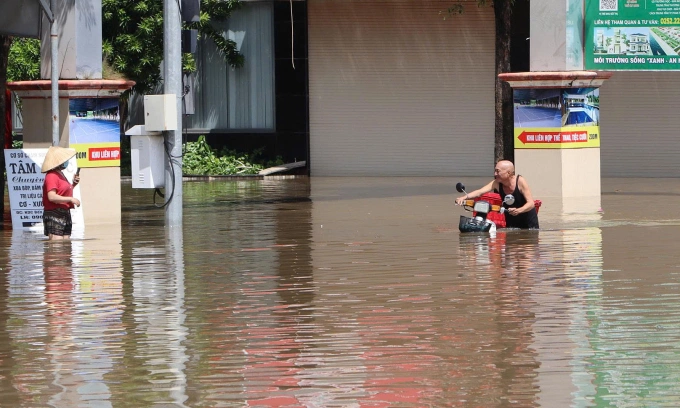 Nước dâng cao ở quốc lộ 1 khiến người dân đi lại khó khăn, sáng 31/10. Ảnh: Việt Quốc