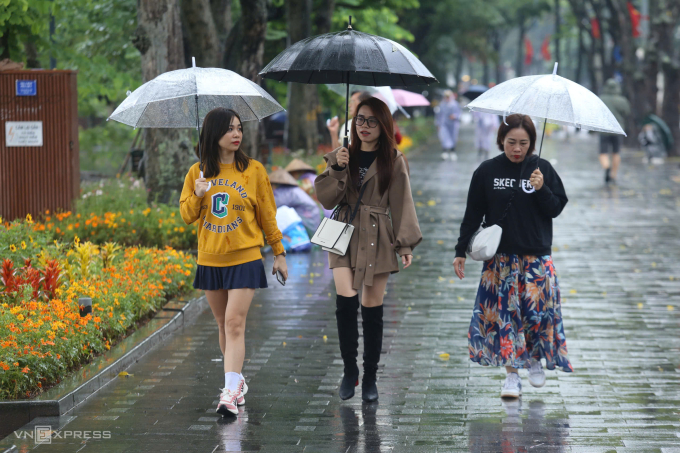 Du khách đi dạo dưới trời mưa lạnh ở Hà Nôi, sáng 1/11. Ảnh: Gia Chính