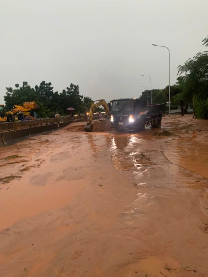 Xe mú, xe ben đang xử lý di chuyển cát đỏ ra khỏi quốc lộ 1. Ảnh: khải Nguyên