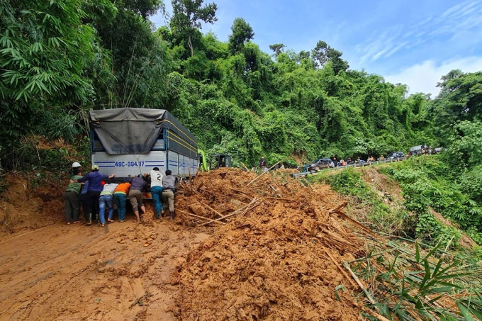 Người dân đẩy ôtô qua đoạn sạt lở trên đèo Gia Bắc. Ảnh: Hoài Thanh