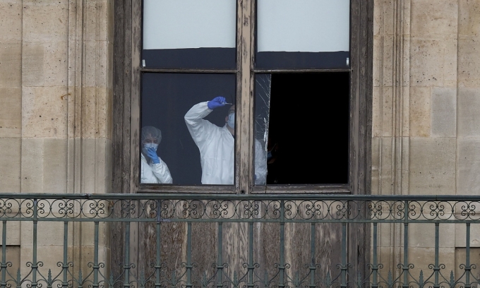 Nhân viên pháp y Pháp kiểm tra cửa sổ bị cắt của một phòng trưng bày tại bảo tàng Louvre ở Paris sau vụ trộm trang sức trị giá hơn 100 triệu USD hôm 19/10. Ảnh: Reuters