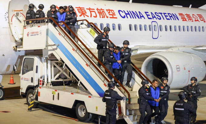 Cảnh sát Trung Quốc áp giải nghi phạm lừa đảo từ Myanmar xuống sân bay tại thành phố Côn Minh năm 2024. Ảnh: AFP
