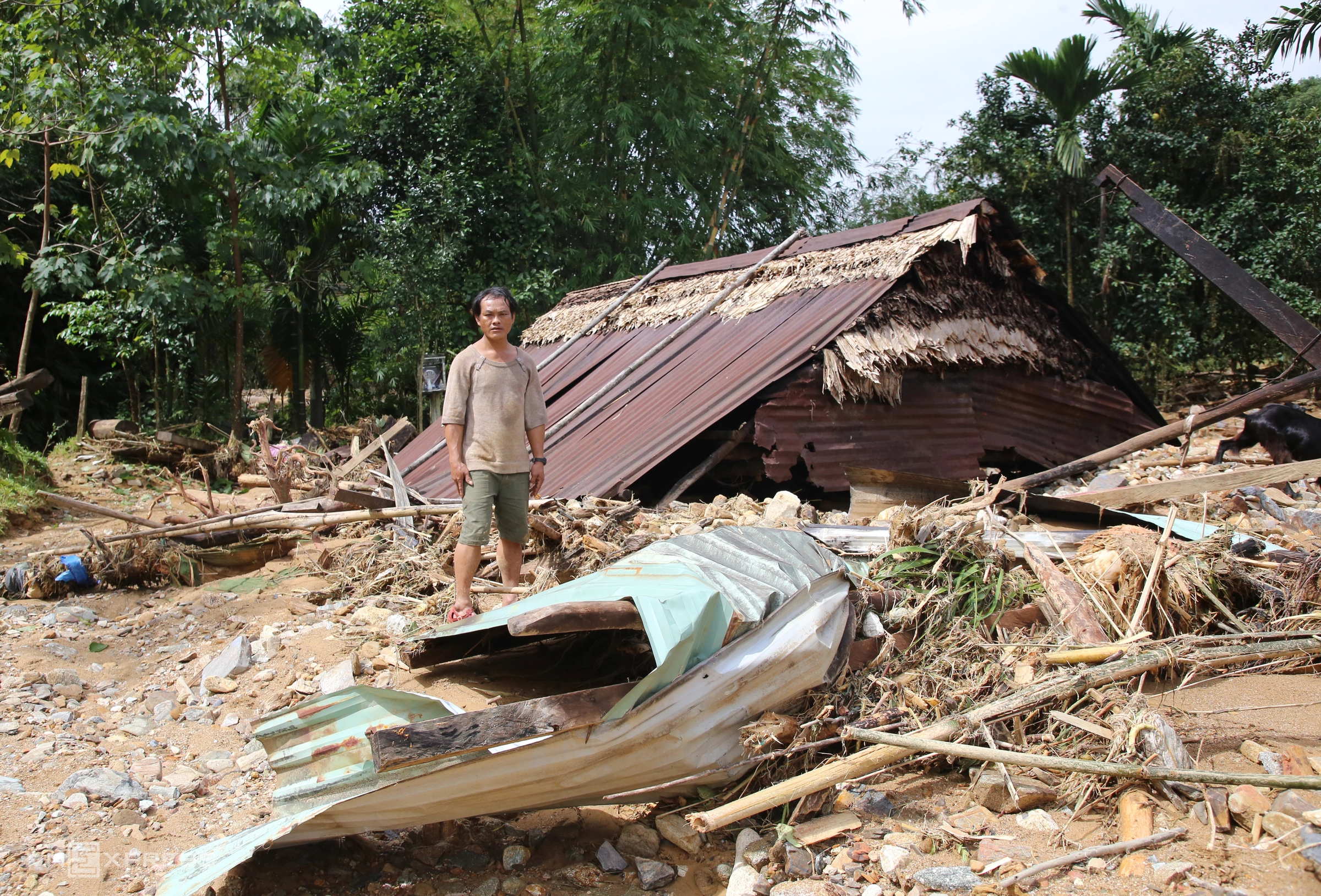Anh Trần Văn Hán (42 tuổi), một trong số 11 hộ dân thuộc nóc Ông Yên, thôn Ngọc Giác, bên một phần mái nhà sau trận lũ quét. Ảnh:Đắc Thành
